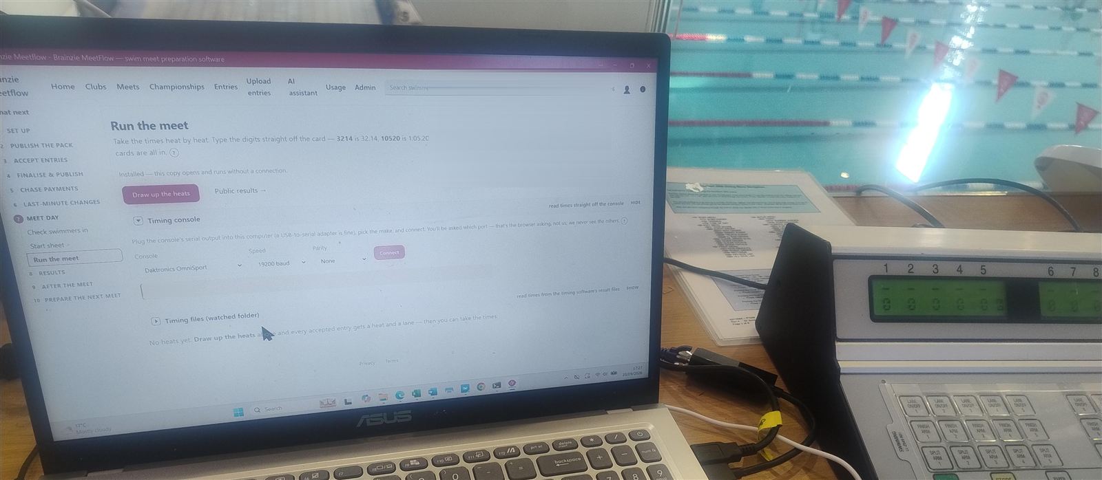 A laptop running Meetflow's timing desk beside the pool's automatic timing console at Crook Log Leisure Centre